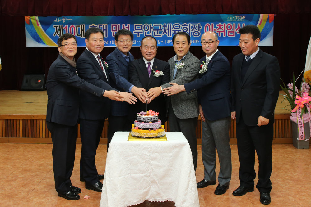 체육회장이취임식에 모인 무안 군수 외 6명의 사람이 손을 모으고 앞을 바라보고 있다.