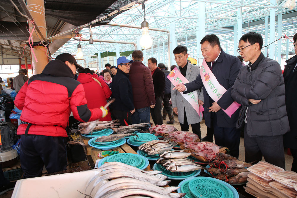 시장 상인에게서 생선을 고르고 있는 무안 군수