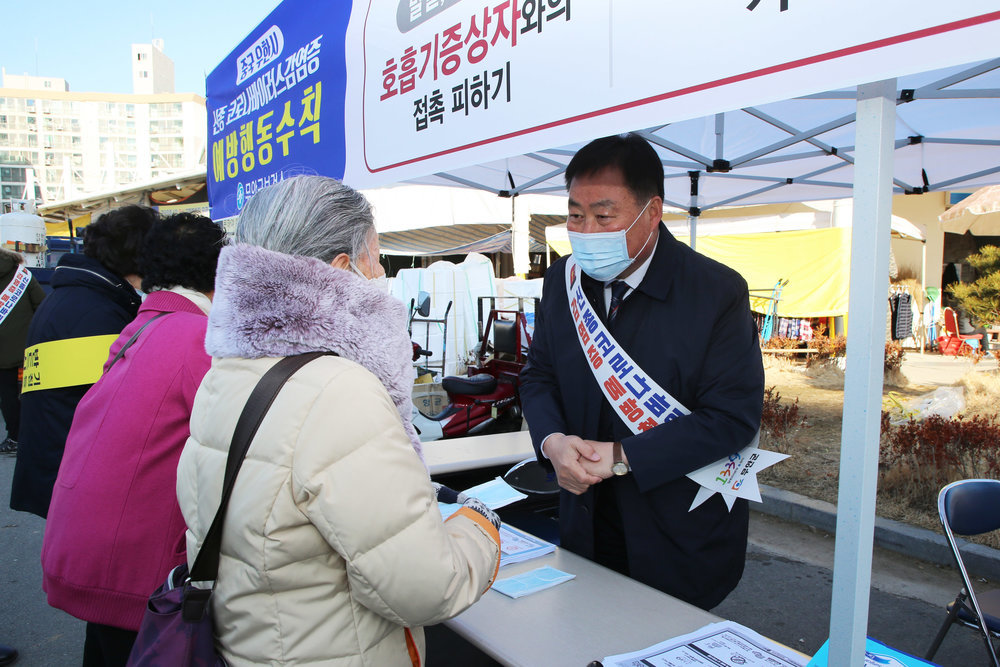 노인 여성에게 마스크를 건네주는 무안 군수