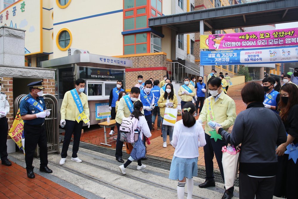 학교 입구앞에서 무안 군수와 직원들이 학생들을 위해 봉사하고 있는 모습