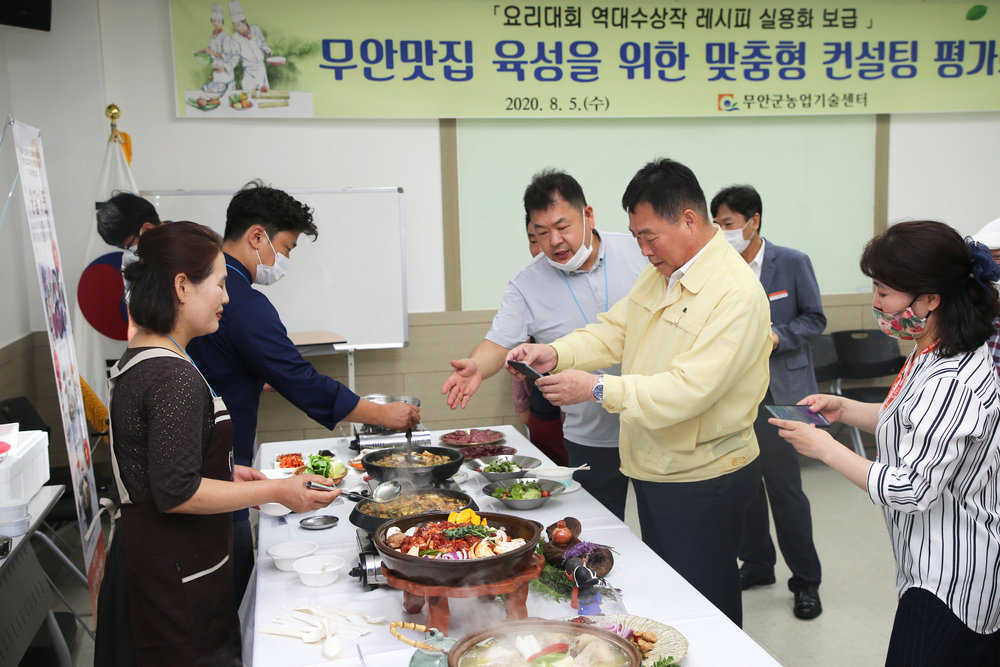 음식 앞에서 휴대폰으로 사진을 촬영중인 무안 군수