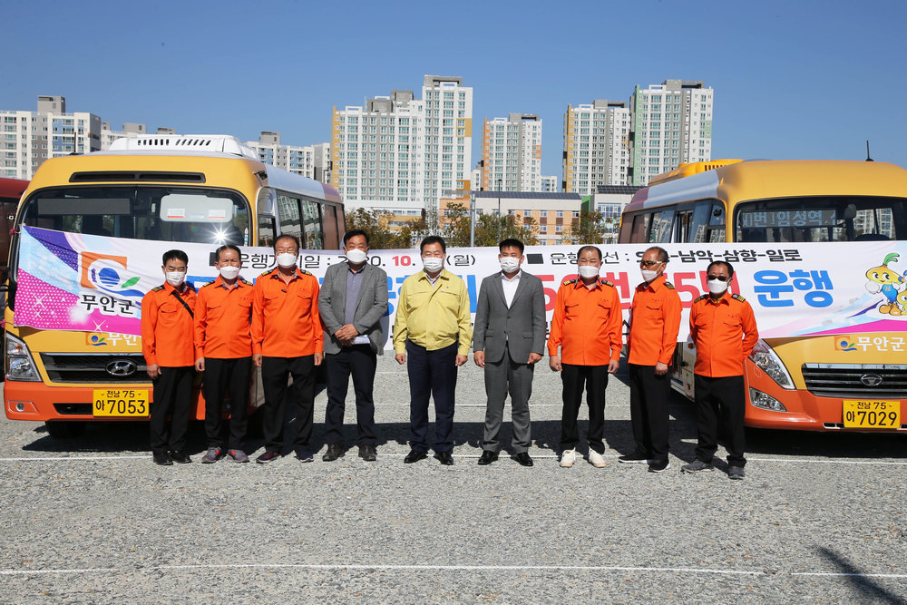 공공형 버스 운행식 진행중인 9명의 사람들이 서있는 모습