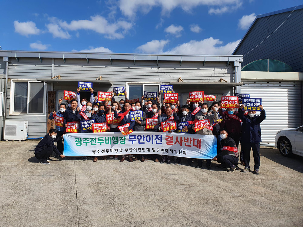 대한 한돈협회 광주 군공항 반대 릴레이 단체사진이며 광주전투비행장 무안이전 결사반대. 광주전투비행장 무안이전 반대 범군민 대책 위원회 현수막을 들고있다. 