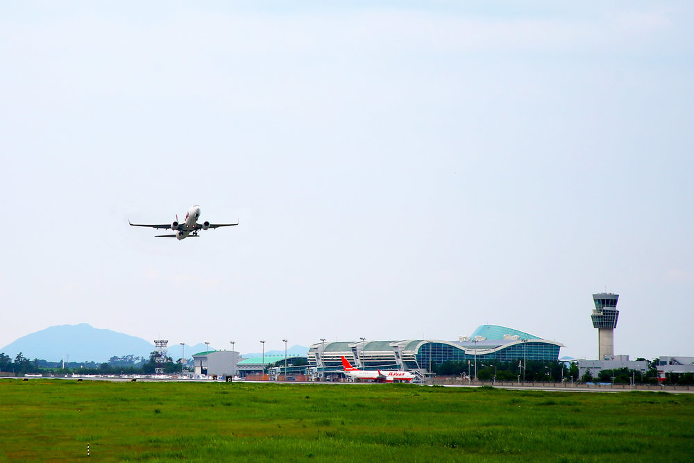 무안국제공항 푸른 잔디밭위로 상승중인 비행기와 고항 전경사진.