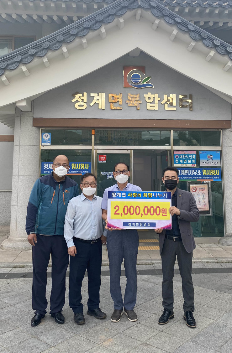 청계면복합센터 앞에서 청계면 사랑의 희망나누기 2,000,000원 청계면청년회 라고 적힌 배너를 들고 기념촬영을 하고 있다