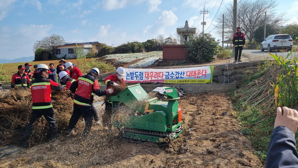 산불전문예방진화대 대원들이 밭에서 파쇄기로 농업부산물 파쇄를 지원하고 있는 모습