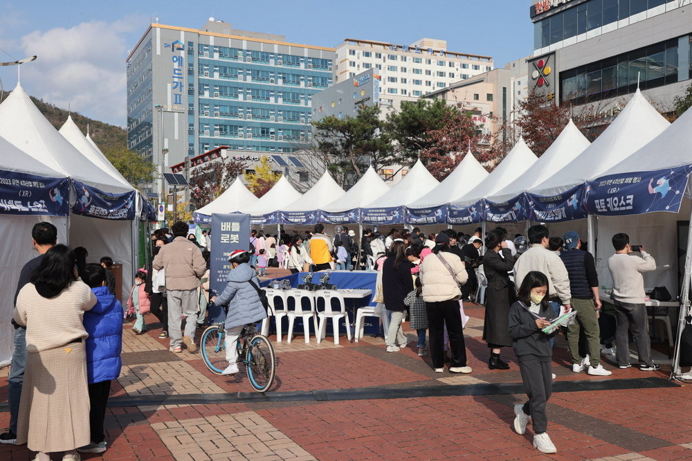 각각의 4차산업체험부스에서 사람들이 다양한 체험을 하고 있는 거리 모습