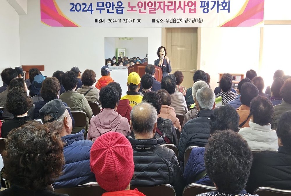 2024 무안읍 노인일자리사업평가회 일시 : 2024.11.7(목) 11:00 장소: 무안읍분회 경로당(1층) 현수막이 걸려있고, 무안읍 읍장이 노인일자리 참여자들을 대상으로 안전교육 및 평가회를 진행하고 있는 모습