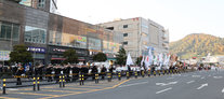 YD축제에 군악단이 와서 연주를 하며 걸어가는 모습을 찍은 사진

